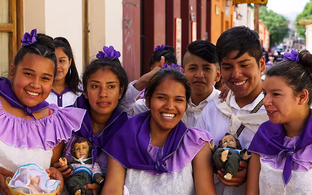 Stolz und glücklich tragen die jungen Menschen ihre Jesusfiguren in Körbchen vor sich her. Zum Fest der Heiligen Drei Könige in Humahuaca, Argentinien