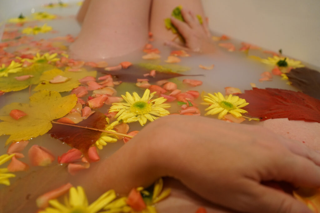 Aktshooting in der Badewanne gefüllt mit Blüten